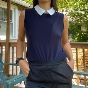 Sleeveless navy top with white collar